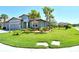 Beautiful gray house featuring lush green lawns, swaying palm trees, and a terra cotta tiled roof at 6800 Dunlin Ct, Sarasota, FL 34241
