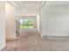 Open foyer with neutral carpeting and views of the backyard through large glass doors at 6800 Dunlin Ct, Sarasota, FL 34241