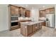 Modern kitchen with stainless steel appliances, central island, and rich wood cabinetry at 6800 Dunlin Ct, Sarasota, FL 34241