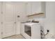 Laundry room equipped with a modern washer and dryer and upper cabinets for storage at 6800 Dunlin Ct, Sarasota, FL 34241