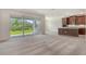 Open living space with glass doors to backyard and a glimpse of the modern kitchen at 6800 Dunlin Ct, Sarasota, FL 34241