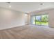 Expansive living room featuring plush carpeting and sliding glass doors to a landscaped backyard at 6800 Dunlin Ct, Sarasota, FL 34241