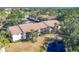 Aerial view of the townhomes featuring mature landscaping, a pond and assigned parking at 752 White Pine Tree Rd # 101, Venice, FL 34285
