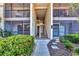 Inviting condo exterior featuring a walkway, second-story porch, and lush landscaping at 752 White Pine Tree Rd # 101, Venice, FL 34285