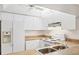 Clean kitchen showcasing white cabinetry, appliances, ceiling fan and neutral countertops at 752 White Pine Tree Rd # 101, Venice, FL 34285