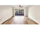 Bright living room featuring wood-look flooring and sliding glass doors to screened lanai at 752 White Pine Tree Rd # 101, Venice, FL 34285