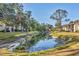 Pond with the townhomes in the background and mature trees at 752 White Pine Tree Rd # 101, Venice, FL 34285