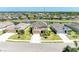 Aerial view of a tan two-story home on a pond with a well-manicured lawn and lush landscaping at 7822 110Th E Ave, Parrish, FL 34219