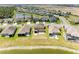 Aerial view of the back of a home and backyard with white fence, nestled in a community by a picturesque pond at 7822 110Th E Ave, Parrish, FL 34219