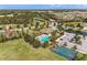 Expansive aerial view of a community clubhouse, pool, and tennis court nestled among trees and serene lakes at 7822 110Th E Ave, Parrish, FL 34219