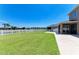 The sprawling backyard features lush green grass and a view of the lake with a white picket fence at 7822 110Th E Ave, Parrish, FL 34219