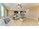 Bright living room with neutral tones, tile flooring, ceiling fan, and staircase to the upper level at 7822 110Th E Ave, Parrish, FL 34219