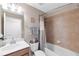 A bathroom has a shower and tub with neutral colored tile at 8205 Grand Estuary Trl # 101, Bradenton, FL 34212