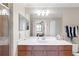Bathroom featuring a wood vanity, white countertop, and a large mirror with decorative lighting at 8205 Grand Estuary Trl # 101, Bradenton, FL 34212