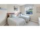 A bedroom has two twin beds with blue and white striped bedding at 8205 Grand Estuary Trl # 101, Bradenton, FL 34212