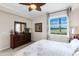 Bedroom with a large window view, decorative dresser, and ceiling fan at 8205 Grand Estuary Trl # 101, Bradenton, FL 34212