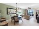 Inviting dining area with stylish furniture, a large mirror, and natural light, open to the living room at 8205 Grand Estuary Trl # 101, Bradenton, FL 34212