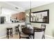 Dining room with modern chandelier and seating for four, next to an open concept kitchen at 8205 Grand Estuary Trl # 101, Bradenton, FL 34212