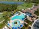 Aerial view of a stunning community pool and lounge area with lush landscaping and nearby golf course at 8205 Grand Estuary Trl # 101, Bradenton, FL 34212