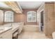 Bright bathroom with double vanity, soaking tub, and plantation shutters for natural light at 8838 Bloomfield Blvd, Sarasota, FL 34238