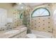 Charming bathroom with decorative green tiled accents, a unique arched window, and shower-tub combo at 8838 Bloomfield Blvd, Sarasota, FL 34238