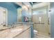 Modern bathroom featuring neutral tiles in shower, granite countertops, and framed glass shower doors at 8838 Bloomfield Blvd, Sarasota, FL 34238