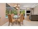 Dining area with glass table and seating for four, overlooks the pool and lanai at 8838 Bloomfield Blvd, Sarasota, FL 34238