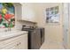 Efficient laundry room with modern washer and dryer, ample storage, and stylish decor at 8838 Bloomfield Blvd, Sarasota, FL 34238