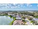 Aerial view of a residential community by a pond, featuring homes with mature trees at 8995 Founders Cir, Palmetto, FL 34221