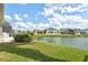 Lush green lawn and landscaping with a picturesque pond view and neighboring houses at 8995 Founders Cir, Palmetto, FL 34221