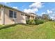 Manicured lawn with view of the home's exterior, patio, and screened enclosure at 8995 Founders Cir, Palmetto, FL 34221