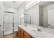Well-lit bathroom featuring double sinks, glass-enclosed shower, and tile flooring at 8995 Founders Cir, Palmetto, FL 34221