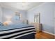 Bright bedroom with ceiling fan, side table with lamp, dresser with mirror and beautiful laminate floors at 8995 Founders Cir, Palmetto, FL 34221