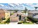 Stunning aerial view of tan house with lush landscaping and a serene waterfront backyard at 8995 Founders Cir, Palmetto, FL 34221