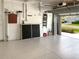 View of the garage with painted floor, overhead storage, and access to outside at 8995 Founders Cir, Palmetto, FL 34221