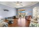 Light-filled living room with sliding glass doors to the lanai, and hardwood floors at 8995 Founders Cir, Palmetto, FL 34221