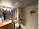 Bathroom featuring tiled shower and tub, single sink vanity, toilet, and vanity mirror at 105 S Obrien St # 213, Tampa, FL 33609
