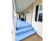 Comfortable covered porch with blue flooring leading to the front door at 112 Park Ter, Venice, FL 34285