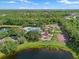 Aerial view showcasing a community pool, tennis courts, playground, and lake, surrounded by lush landscaping at 11713 Goldenrod Ave, Bradenton, FL 34212