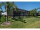 The lush green backyard features a screened pool, privacy fence, palm trees, and well-manicured landscaping at 11713 Goldenrod Ave, Bradenton, FL 34212