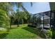 A beautiful backyard features a screened pool, privacy fence, lush tropical landscaping, and well-maintained lawn at 11713 Goldenrod Ave, Bradenton, FL 34212