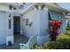 Charming front exterior of a home, featuring lush landscaping, a cozy bench, and a welcoming entrance at 11713 Goldenrod Ave, Bradenton, FL 34212