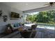 Screened-in patio with wicker furniture, mounted TV, and a view of the refreshing swimming pool and backyard at 11713 Goldenrod Ave, Bradenton, FL 34212