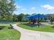 A shady, covered playground with slides and swings next to a walking path, providing a fun and accessible recreation space at 11713 Goldenrod Ave, Bradenton, FL 34212