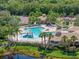 Community pool area featuring a pool with a slide, hot tub, lounge chairs, and a building with outdoor seating at 11713 Goldenrod Ave, Bradenton, FL 34212