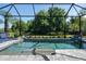 Beautiful screened pool showcasing mature landscaping, a sun shelf, and a tranquil backyard setting at 11713 Goldenrod Ave, Bradenton, FL 34212