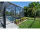 The screened pool area showcases views of the lush backyard and tropical landscaping with beautiful pavers at 11713 Goldenrod Ave, Bradenton, FL 34212