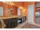 Bright bathroom with double sinks, dark cabinetry, and a large mirror with decorative lighting at 12012 Legacy Estates Blvd, Sarasota, FL 34238