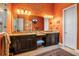 Elegant bathroom featuring dual vanities, dark wood cabinets, and a decorative wall accent at 12012 Legacy Estates Blvd, Sarasota, FL 34238