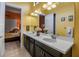 Well-lit bathroom with a double vanity, decorative mirror, and a view into the bedroom at 12012 Legacy Estates Blvd, Sarasota, FL 34238